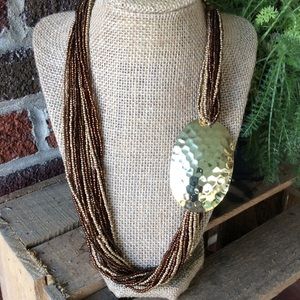 Multi strands of brown and gold tone beads.